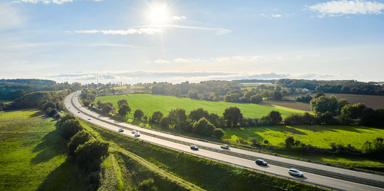Autoroute traversant une campagne verdoyante vue du ciel