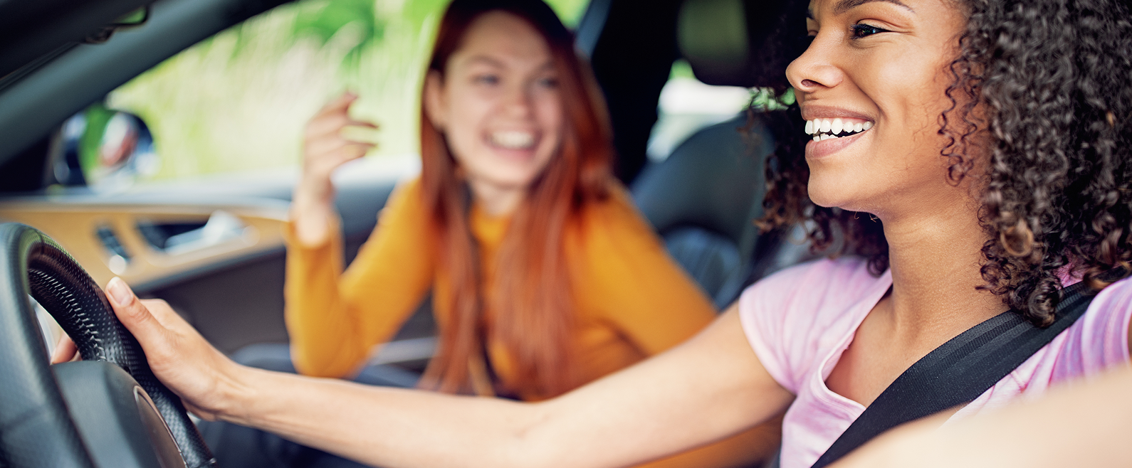 Personnes à l’intérieur d’une voiture, avec une personne au volant et une autre sur le siège passager avant.